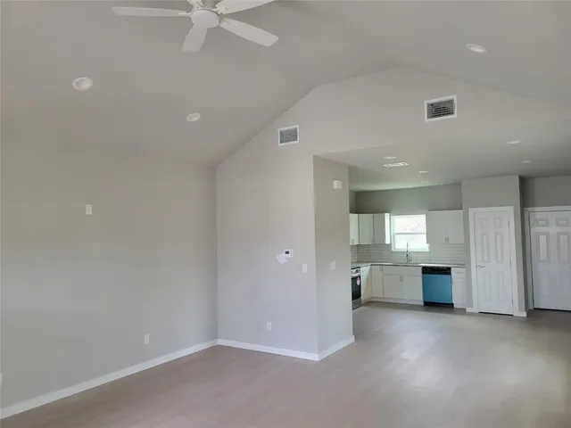 an empty room with a kitchen and a sink