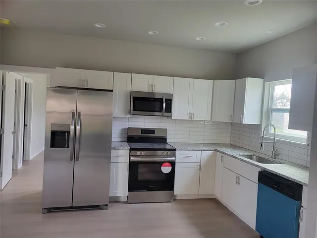 a kitchen with a sink stainless steel appliances and cabinets