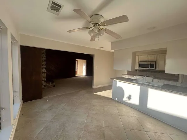 a view of a kitchen with a sink and dishwasher cabinet with a fireplace