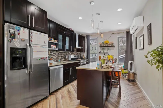 a kitchen with stainless steel appliances kitchen island granite countertop a refrigerator and a stove top oven