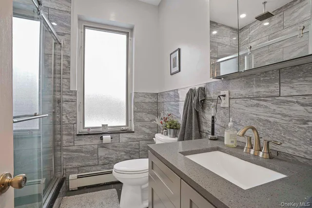 a bathroom with a sink vanity granite toilet and a mirror