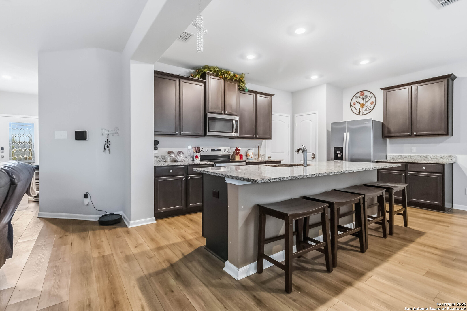 a kitchen with kitchen island granite countertop wooden floors and wooden cabinets