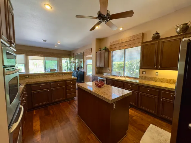 a kitchen with stainless steel appliances granite countertop a sink a stove and a refrigerator