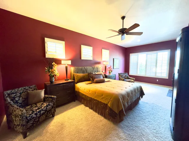 a spacious bedroom with a bed couch and window