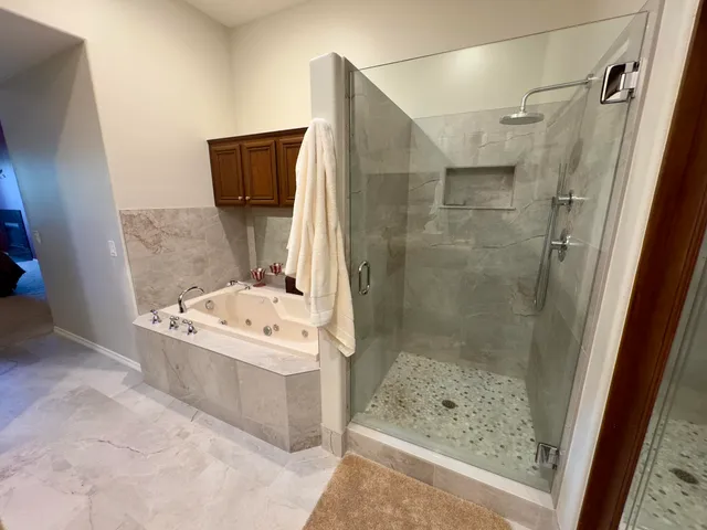 a bathroom with a tub a sink and mirror