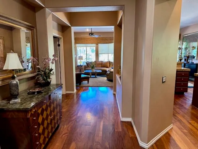 a view of a hallway with wooden floor and furniture