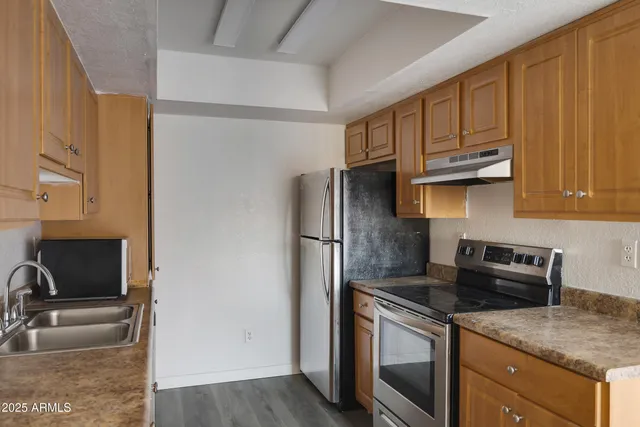 a kitchen with stainless steel appliances granite countertop a refrigerator sink and stove