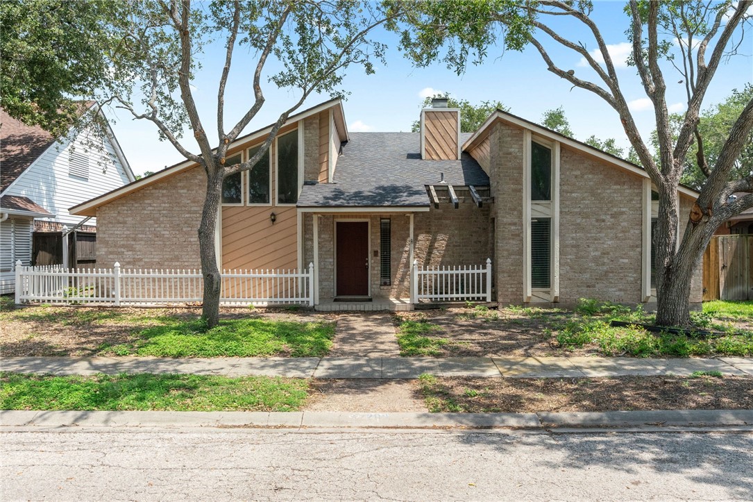7209 Candy Ridge Road Corpus Christi, TX 78413 - Photo 2 of 24 a front view of a house with a yard and a garage