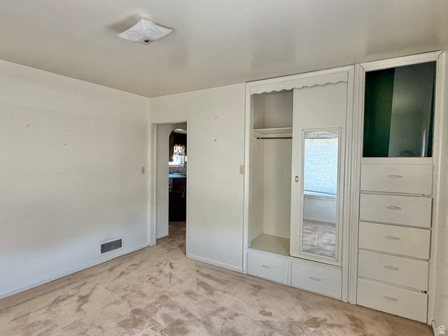 196 North 5th West Price, UT 84501 - Photo 12 of 27 Recessed built-in cabinetry featuring a hanging rod, mirrored panel, and multiple storage drawers