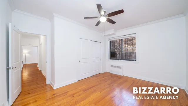 a bedroom with a bed and a ceiling fan
