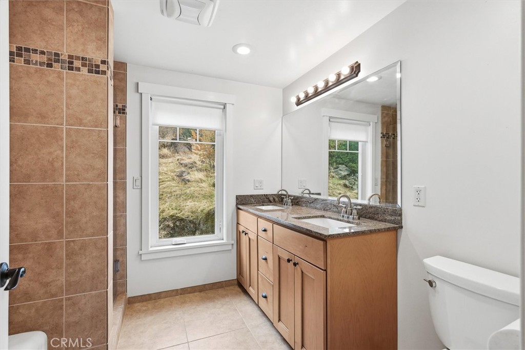 4489 Varain Road Mariposa, CA 95338 - Photo 18 of 39 a bathroom with a granite countertop sink a toilet a mirror and window