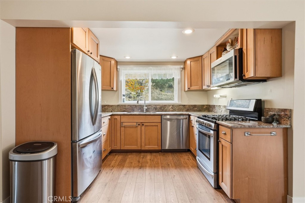 4489 Varain Road Mariposa, CA 95338 - Photo 21 of 39 a kitchen with stainless steel appliances granite countertop a stove a refrigerator a sink and dishwasher with wooden floor