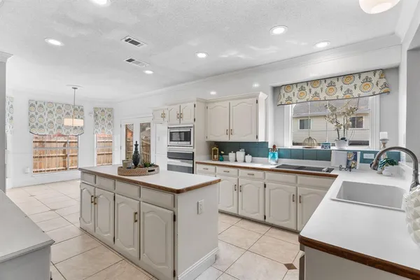 a kitchen with sink stove and white cabinets