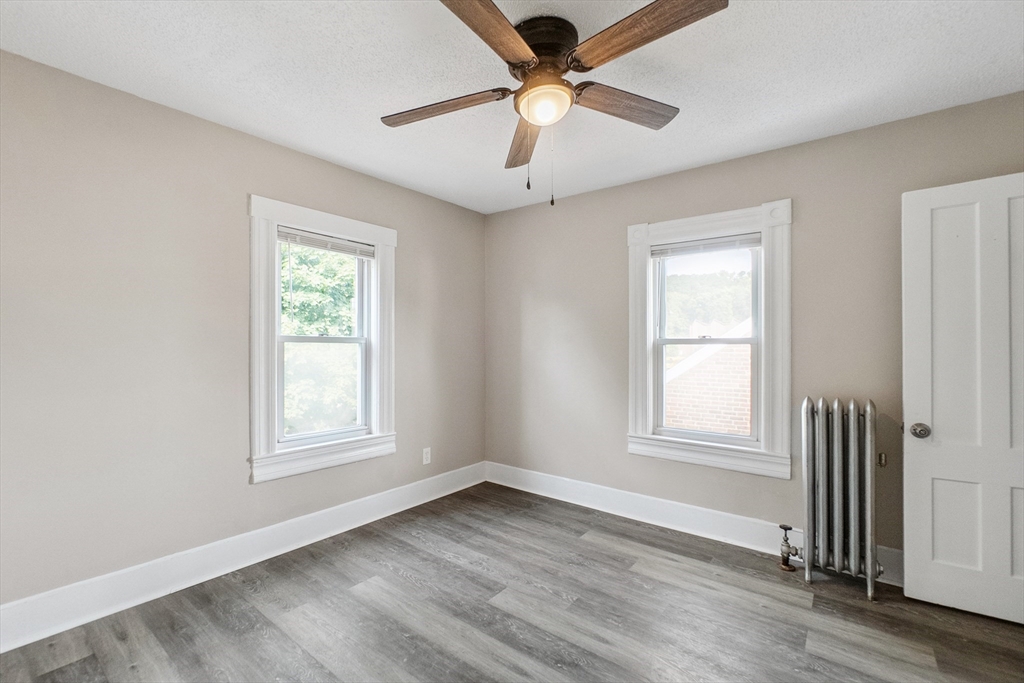 26 Olivine Street Chicopee, MA 01013 - Photo 18 of 26 an empty room with wooden floor ceiling fan and windows