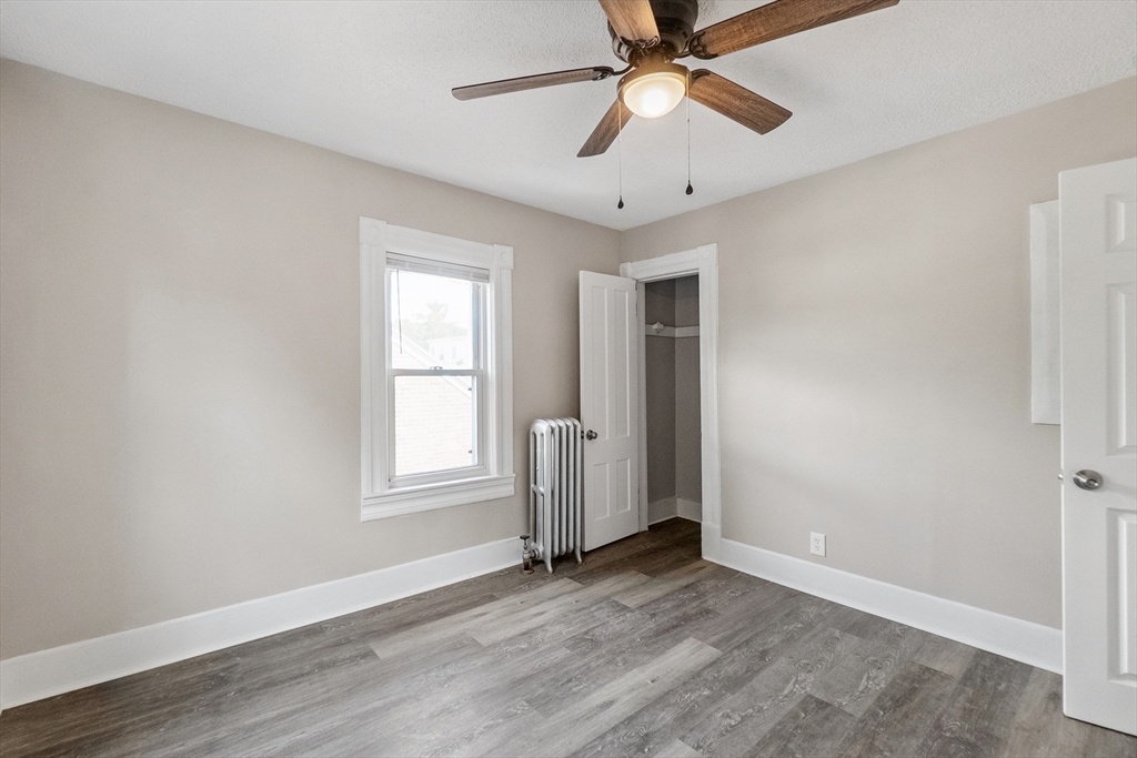 26 Olivine Street Chicopee, MA 01013 - Photo 19 of 26 an empty room with wooden floor chandelier fan and windows