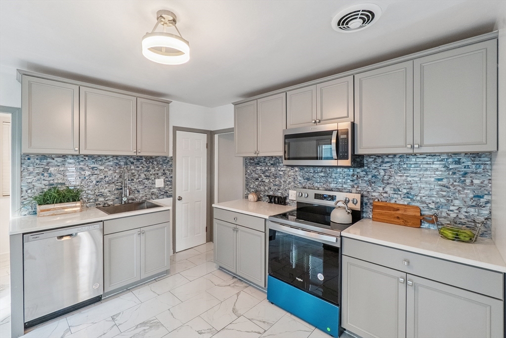 26 Olivine Street Chicopee, MA 01013 - Photo 7 of 26 a kitchen with white cabinets and stainless steel appliances