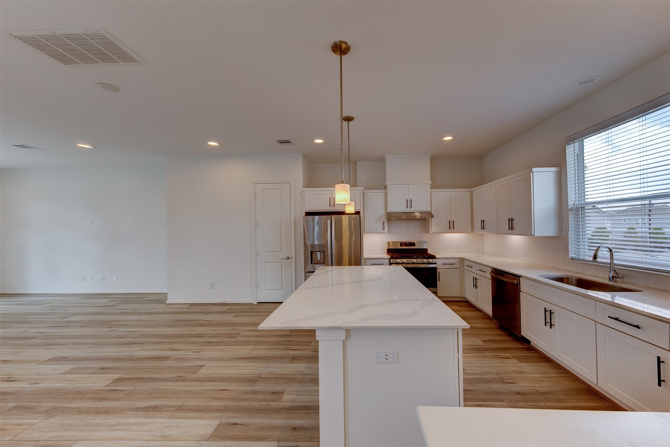1526 Ojeman Road, Unit A Houston, TX 77055 - Photo 21 of 34 a kitchen with stainless steel appliances kitchen island granite countertop a stove a sink a refrigerator and white cabinets with wooden floor
