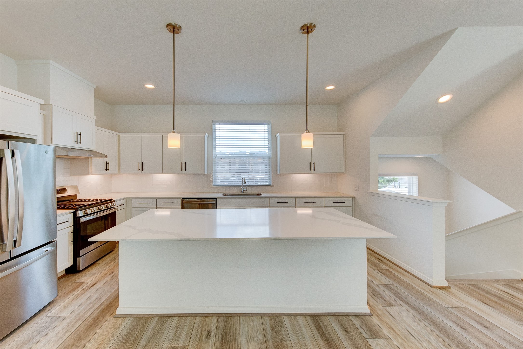 1526 Ojeman Road, Unit A Houston, TX 77055 - Photo 22 of 34 a large kitchen with kitchen island a stove a sink a center island and wooden floor