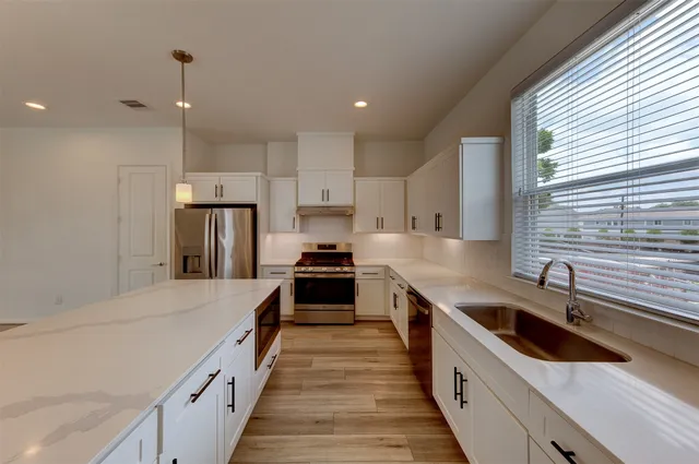 a kitchen with stainless steel appliances a sink stove and refrigerator