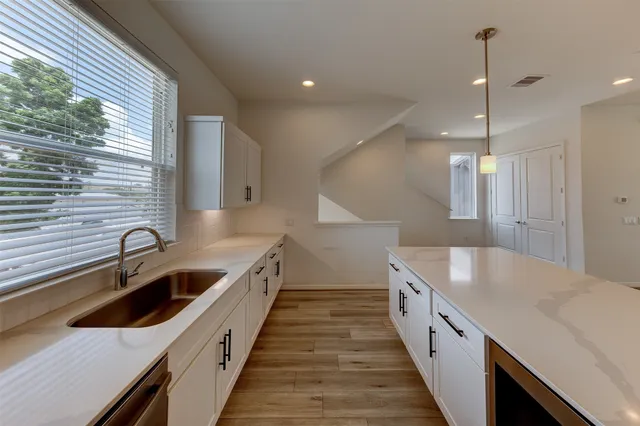 a kitchen with granite countertop a sink and a wooden floor
