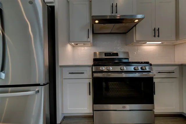 a stove top oven sitting inside of a kitchen