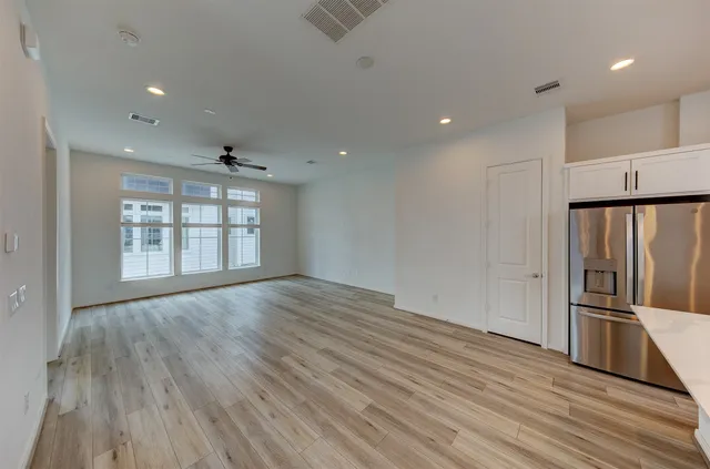 a view of a livingroom with a ceiling fan and wooden floor