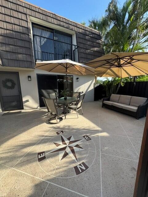 1509 15th Court Jupiter, FL 33477 - Photo 13 of 19 a view of a patio with table and chairs under an umbrella with a barbeque