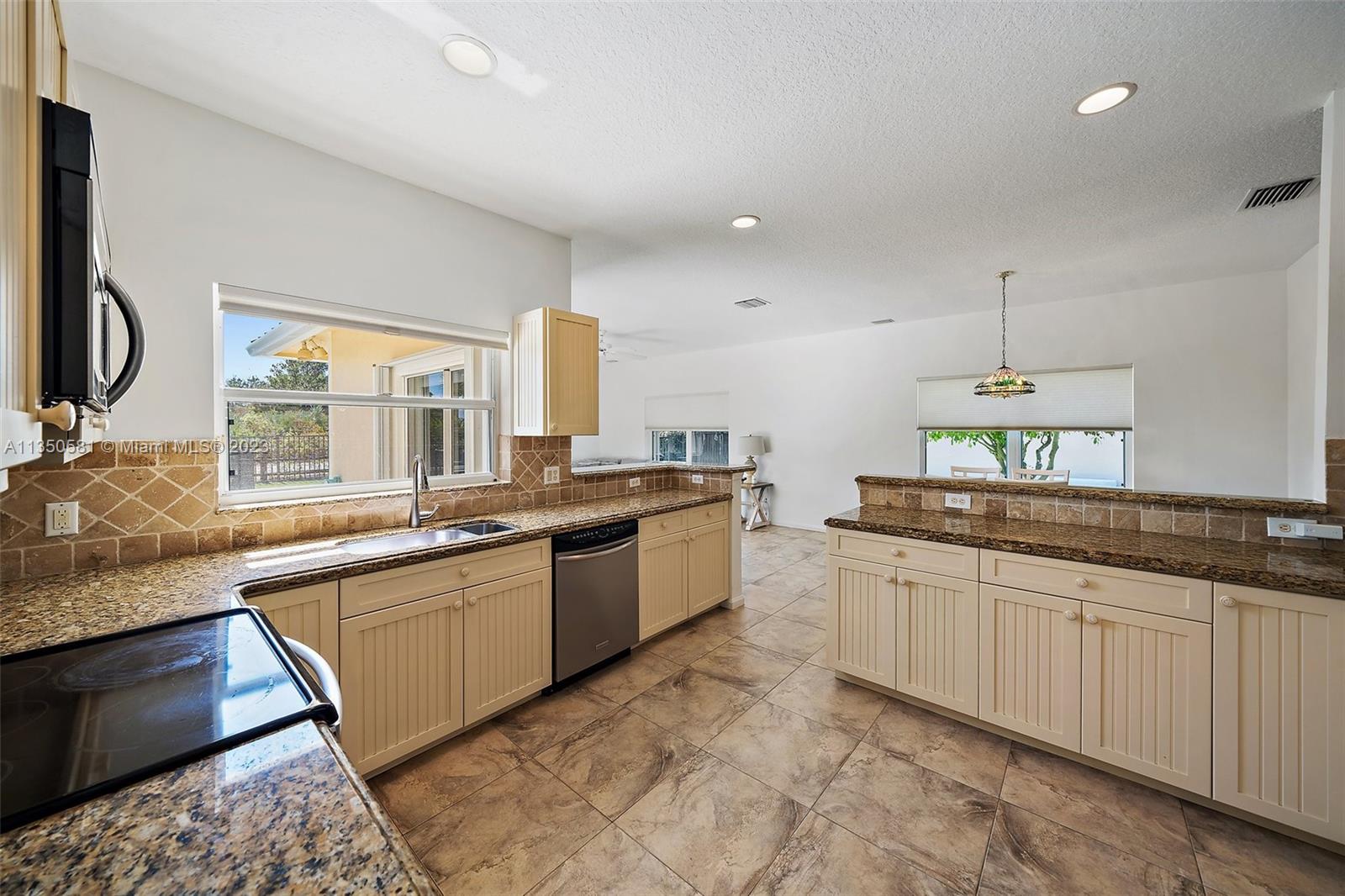 32 Coconut Lane Tequesta, FL 33469 - Photo 14 of 56 a large kitchen with a sink and dishwasher a stove top oven with wooden floor