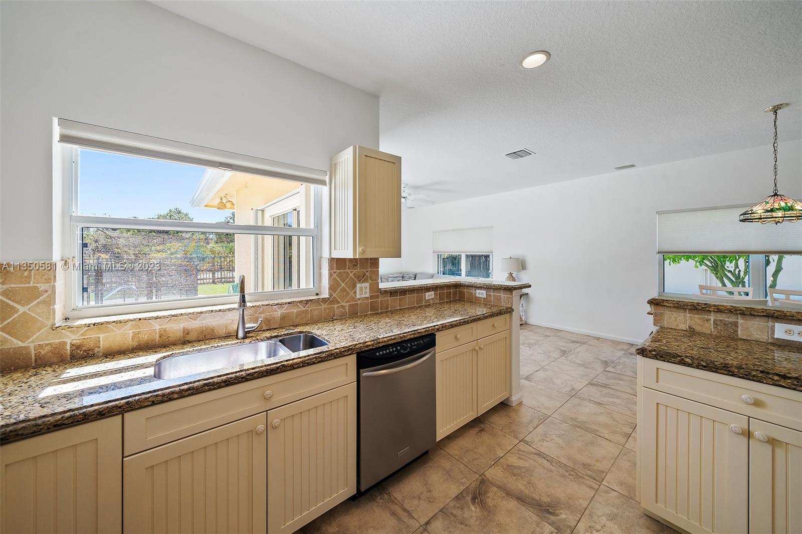 32 Coconut Lane Tequesta, FL 33469 - Photo 15 of 56 a kitchen with granite countertop a sink and a white wooden cabinets
