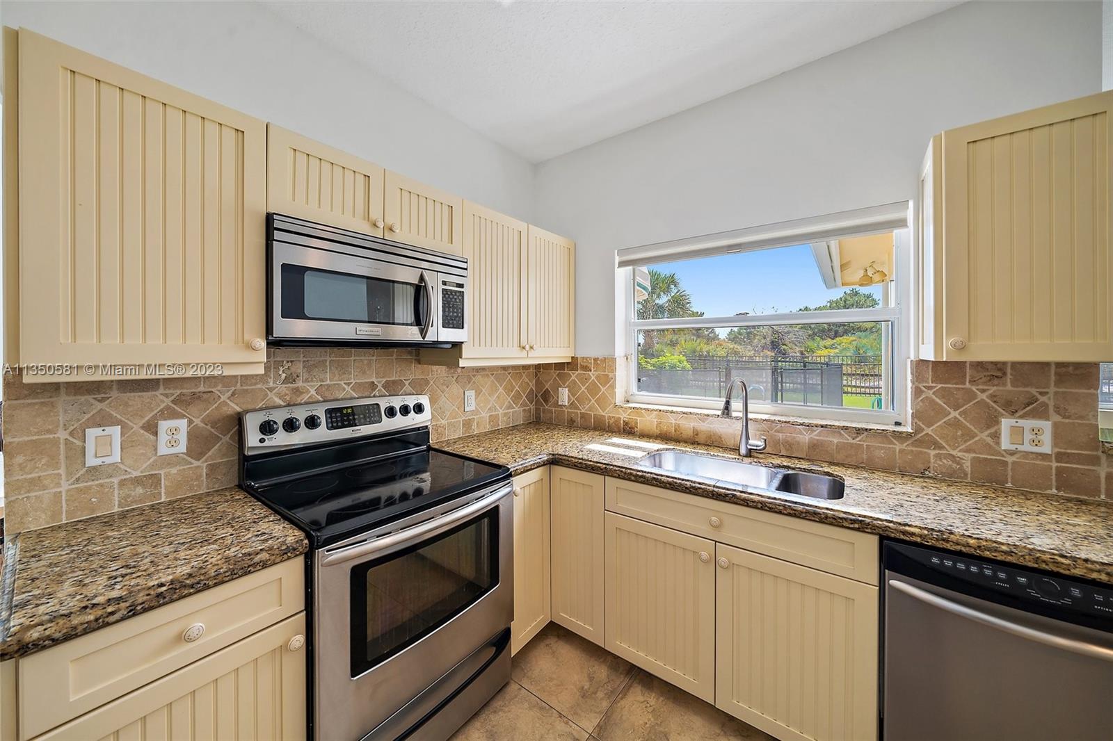 32 Coconut Lane Tequesta, FL 33469 - Photo 17 of 56 a kitchen with sink a microwave and cabinets