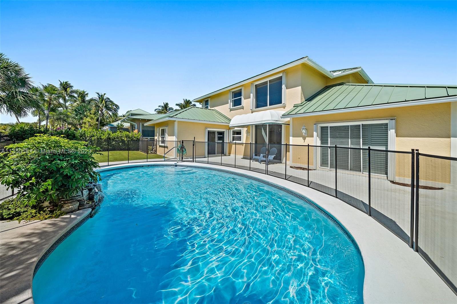 32 Coconut Lane Tequesta, FL 33469 - Photo 44 of 56 a front view of a house with a yard table and chairs