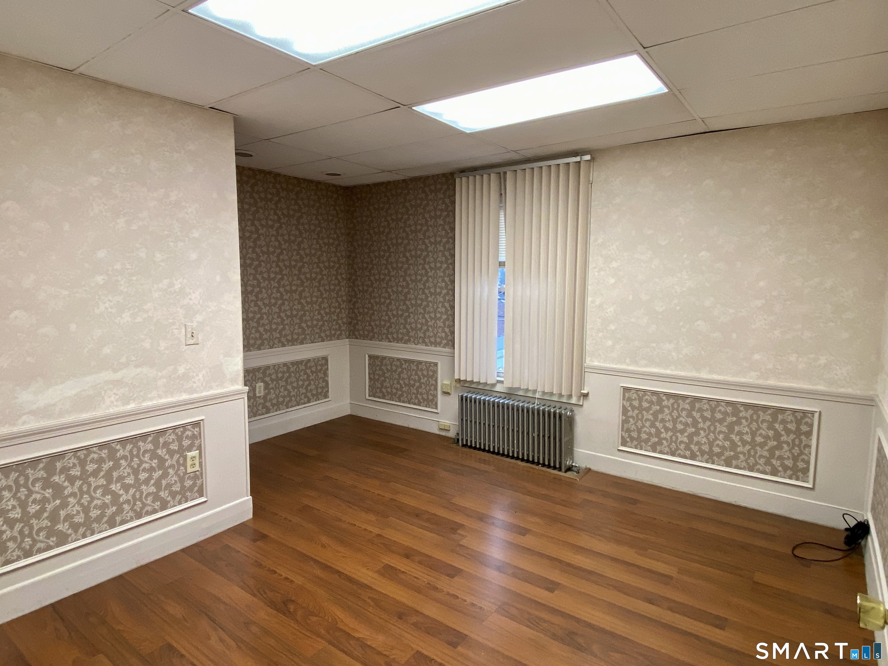 140 Union Street Vernon, CT 06066 - Photo 14 of 26 an empty room with wooden floor cabinet and windows