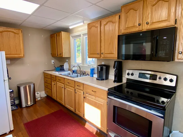 a kitchen with stainless steel appliances granite countertop a stove a sink and a microwave