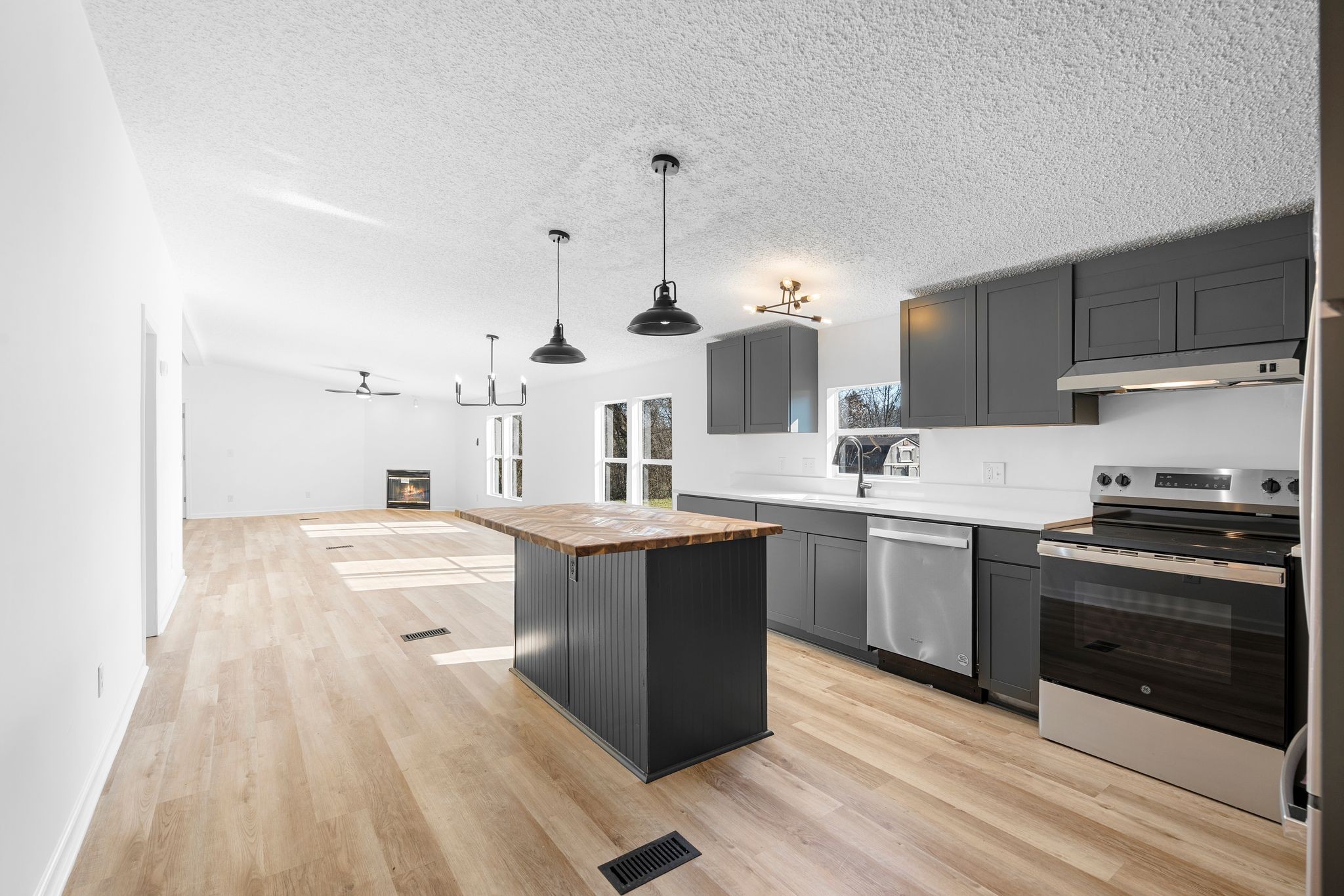 3092 McKibbon Road Culleoka, TN 38451 - Photo 20 of 41 a kitchen with kitchen island a sink dishwasher stove and white cabinets with wooden floor