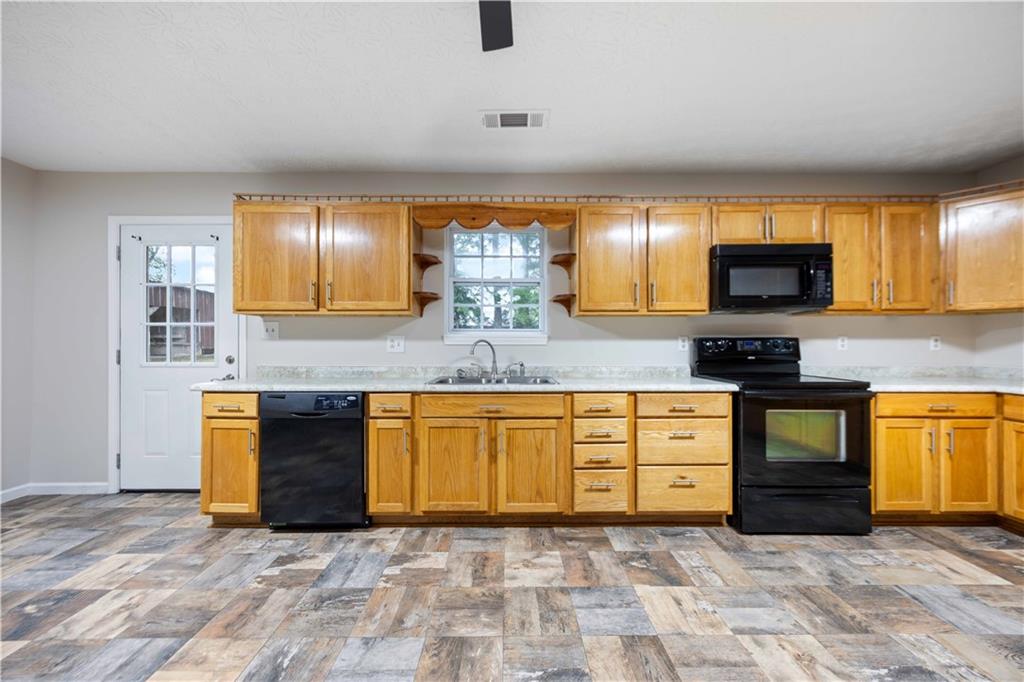 25 Gas Line Road Phenix City, AL 36870 - Photo 12 of 52 Kitchen featuring black appliances, light countertops, and open shelves