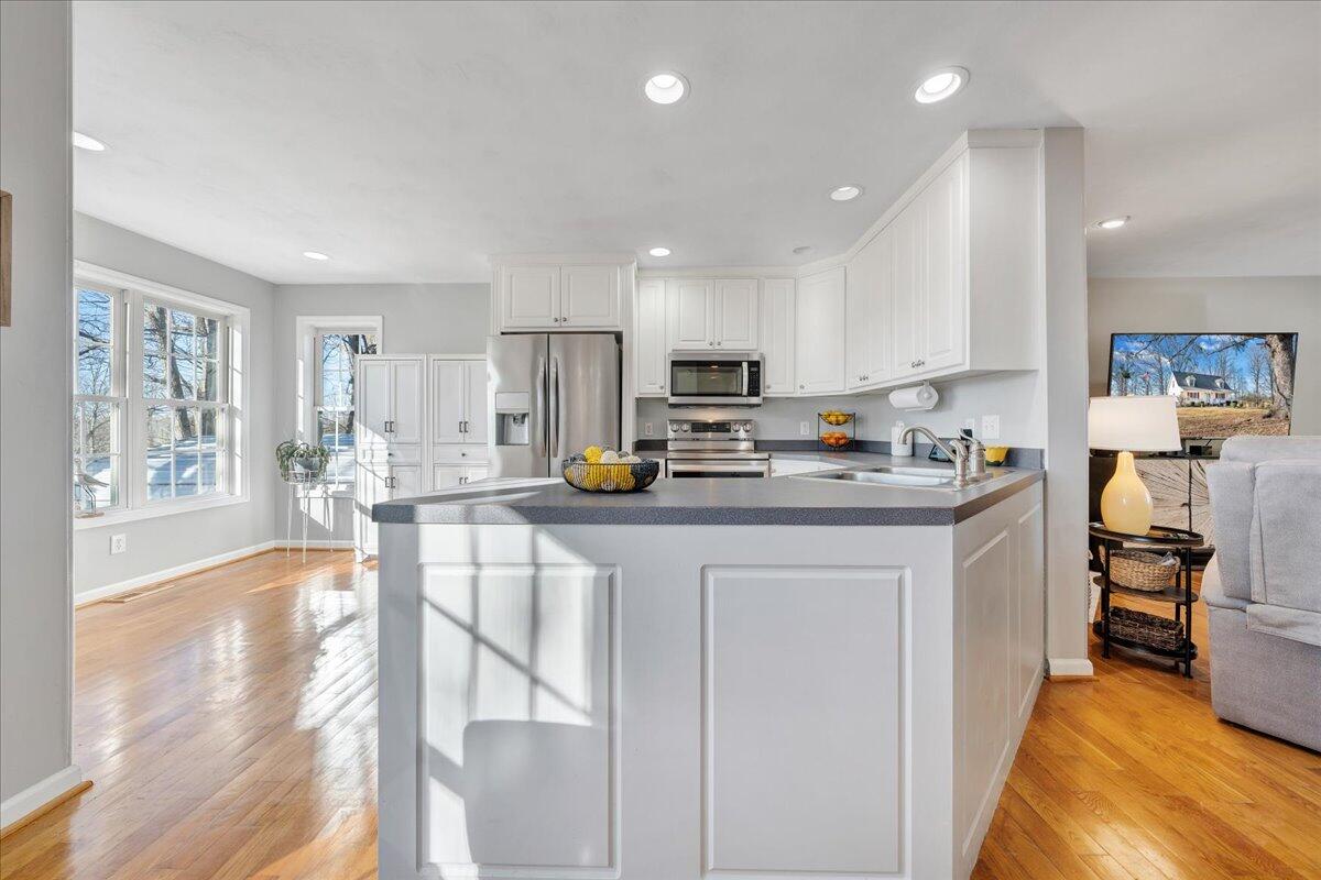 2695 Hardy Road Hardy, VA 24101 - Photo 7 of 36 a kitchen with stainless steel appliances granite countertop a refrigerator top oven a stove a sink a dining table and chairs with wooden floor