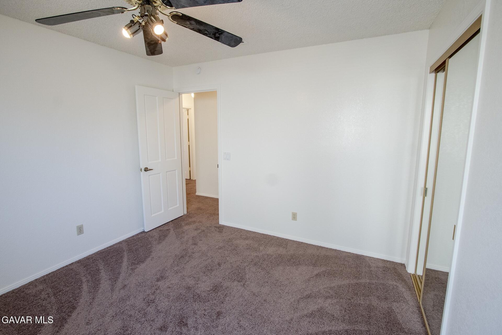 44318 33rd Street West Lancaster, CA 93536 - Photo 28 of 29 an empty room with a chandelier fan and a chandelier fan