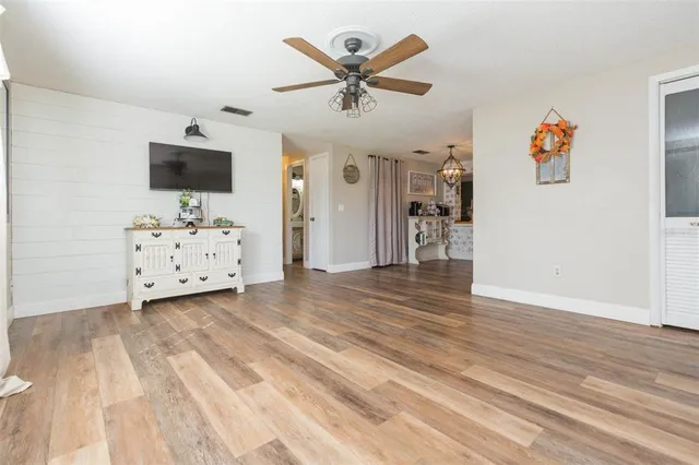 a view of a livingroom with wooden floor and a ceiling fan