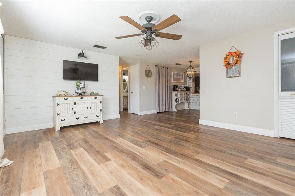 821 Walnut Drive Seffner, FL 33584 - Photo 8 of 19 a view of a livingroom with wooden floor and a ceiling fan