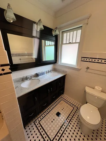 a bathroom with a sink a toilet and mirror