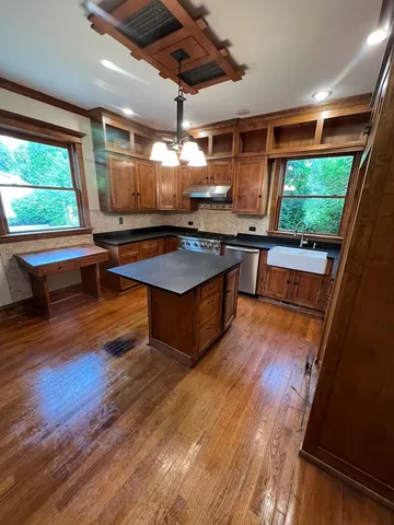 a kitchen with stainless steel appliances granite countertop a sink a stove and wooden floor