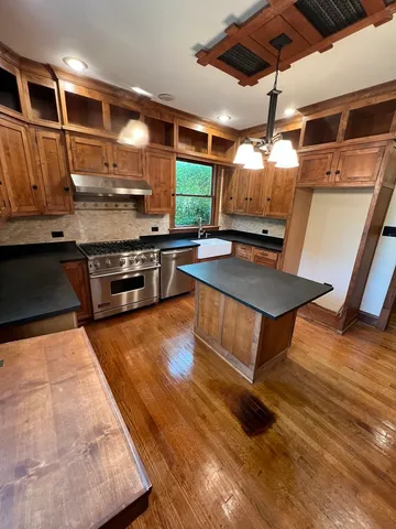 a kitchen with stainless steel appliances granite countertop a sink and a stove
