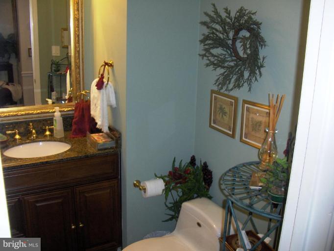 6811 Mallow Court Springfield, VA 22152 - Photo 25 of 30 a bathroom with a granite countertop sink and a toilet