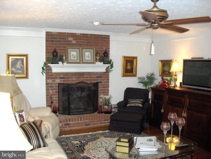 6811 Mallow Court Springfield, VA 22152 - Photo 5 of 30 a living room with furniture a flat screen tv and a fireplace