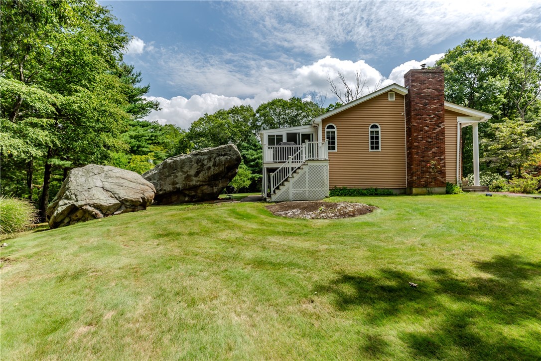 99 Tower Hill Road Cumberland, RI 02864 - Photo 38 of 43 Side of the home featuring a special rock that has become a cherished monument and meaningful part of the sellers’ memories with their children.
