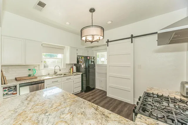 a kitchen with a refrigerator and a stove top oven