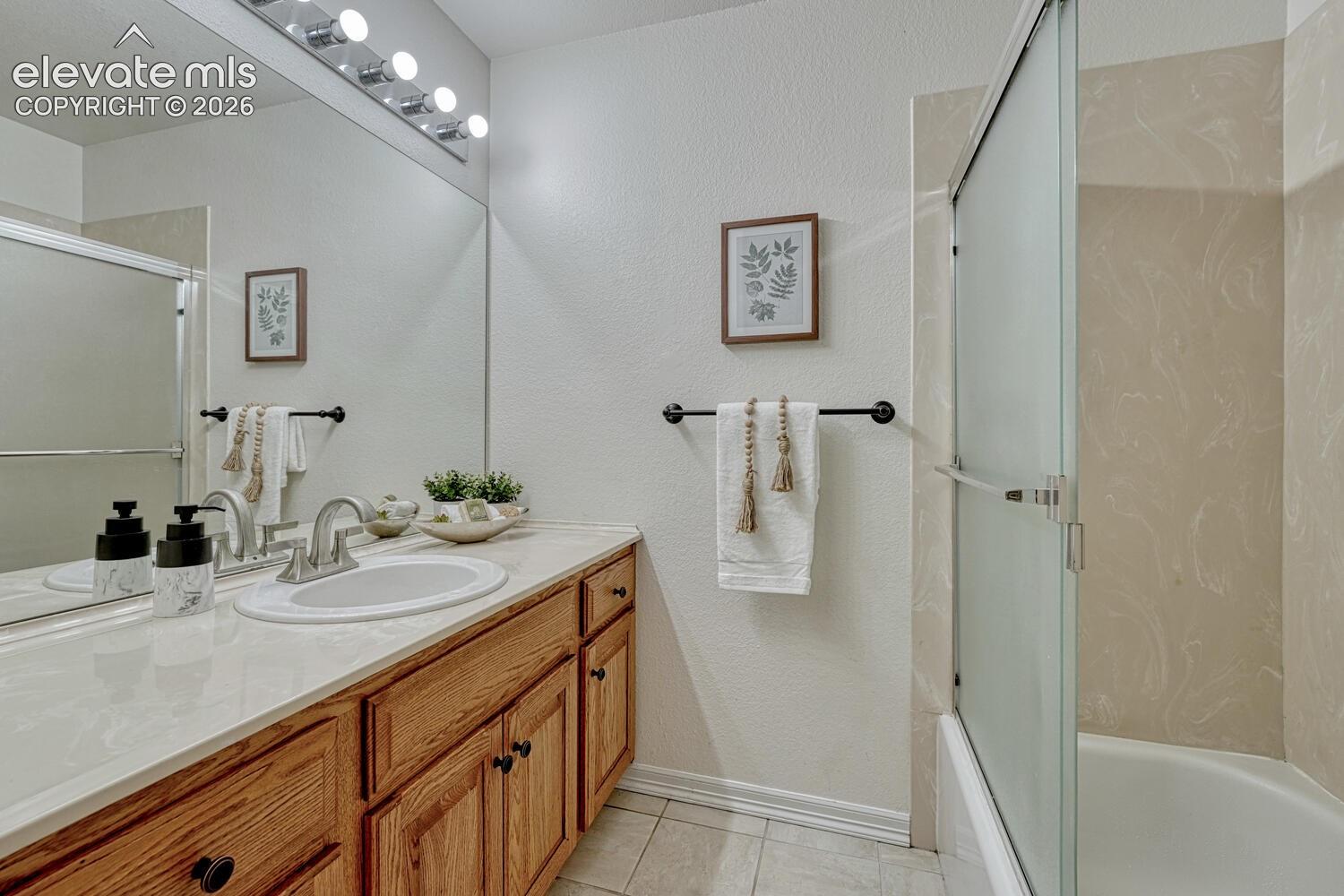 15430 Bar X Road Colorado Springs, CO 80908 - Photo 42 of 50 Full Basement Bathroom with vanity, mirror, and tiled tub/shower.