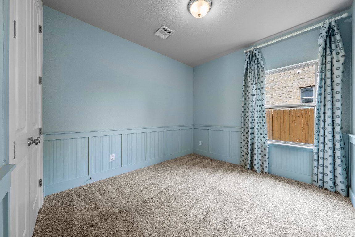 20525 Martin Lane Pflugerville, TX 78660 - Photo 23 of 40 This secondary bedroom packs personality with paneled walls, cool tones, and custom drapes.