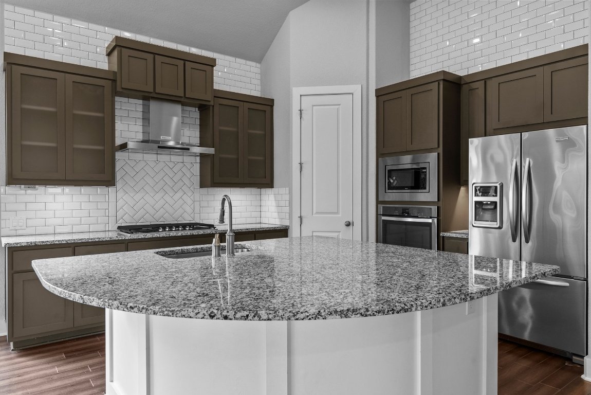 20525 Martin Lane Pflugerville, TX 78660 - Photo 3 of 40 The kitchen is a true showstopper—wrapped in floor-to-ceiling subway tile, with granite counters, custom cabinetry, stainless steel appliances, and a center island ready for action.