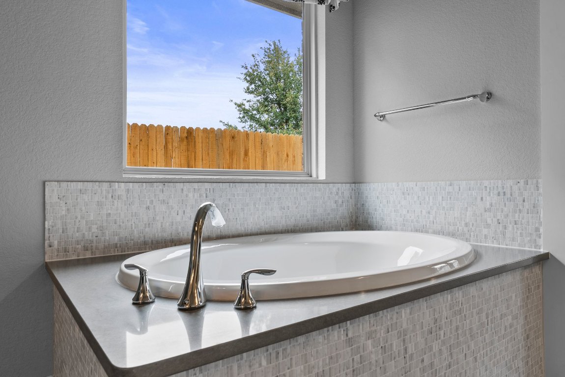 20525 Martin Lane Pflugerville, TX 78660 - Photo 8 of 40 Sculptural and serene, the soaking tub glows beneath picture-perfect light—your private spa, on demand.